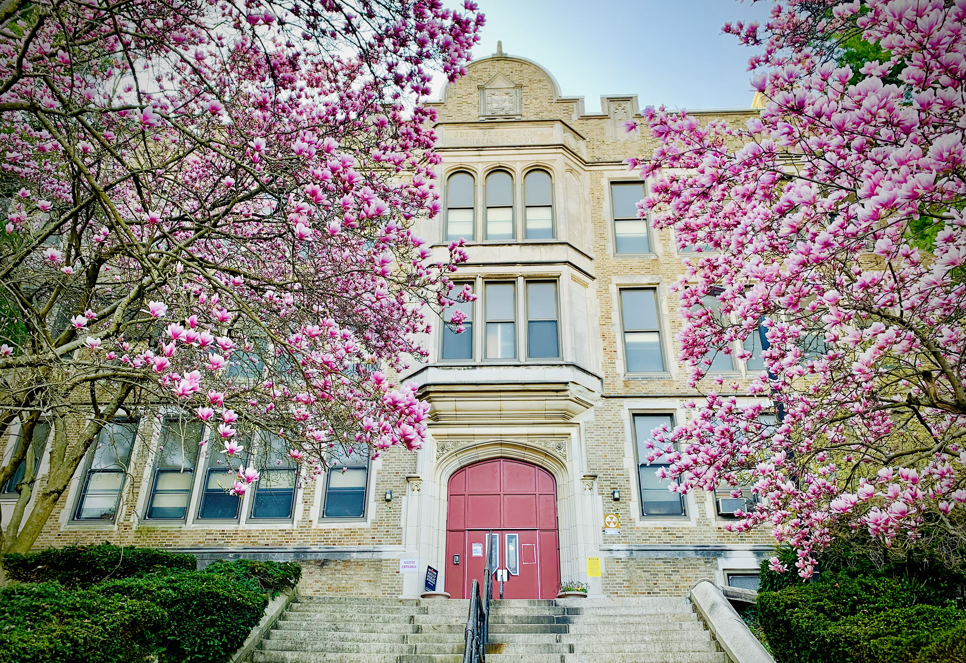 John S. Jenks Academy for the Arts & Sciences Building in Spring Front entrance of John S. Jenks Academy for the Arts & Sciences framed by blooming pink magnolia trees in spring.
